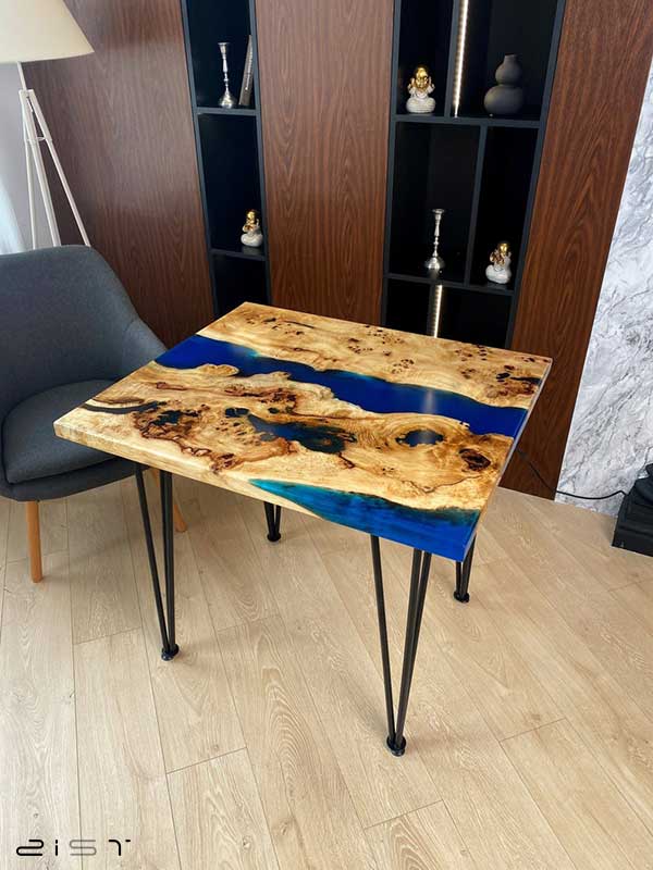در این تصویر یک مدل میز ناهار خوری چهار نفره مربع چوب و رزین را مشاهده میکنید